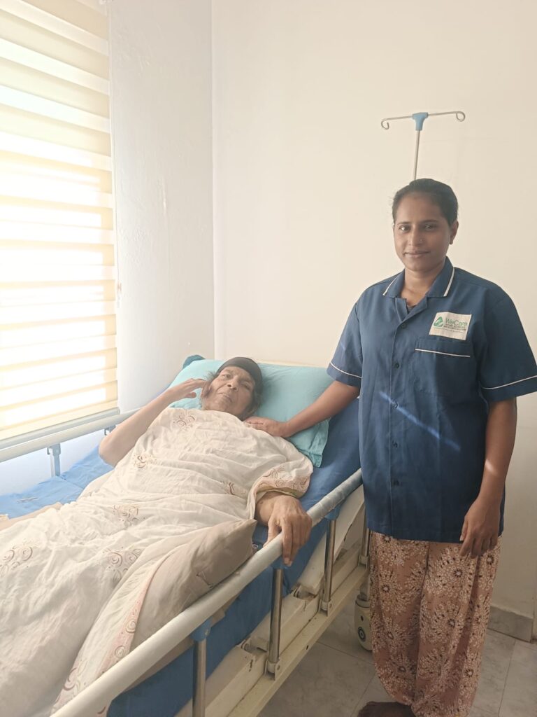 WeCare caregiver helping a senior walk indoors at home in Mangaluru (Nursing Gallery)
